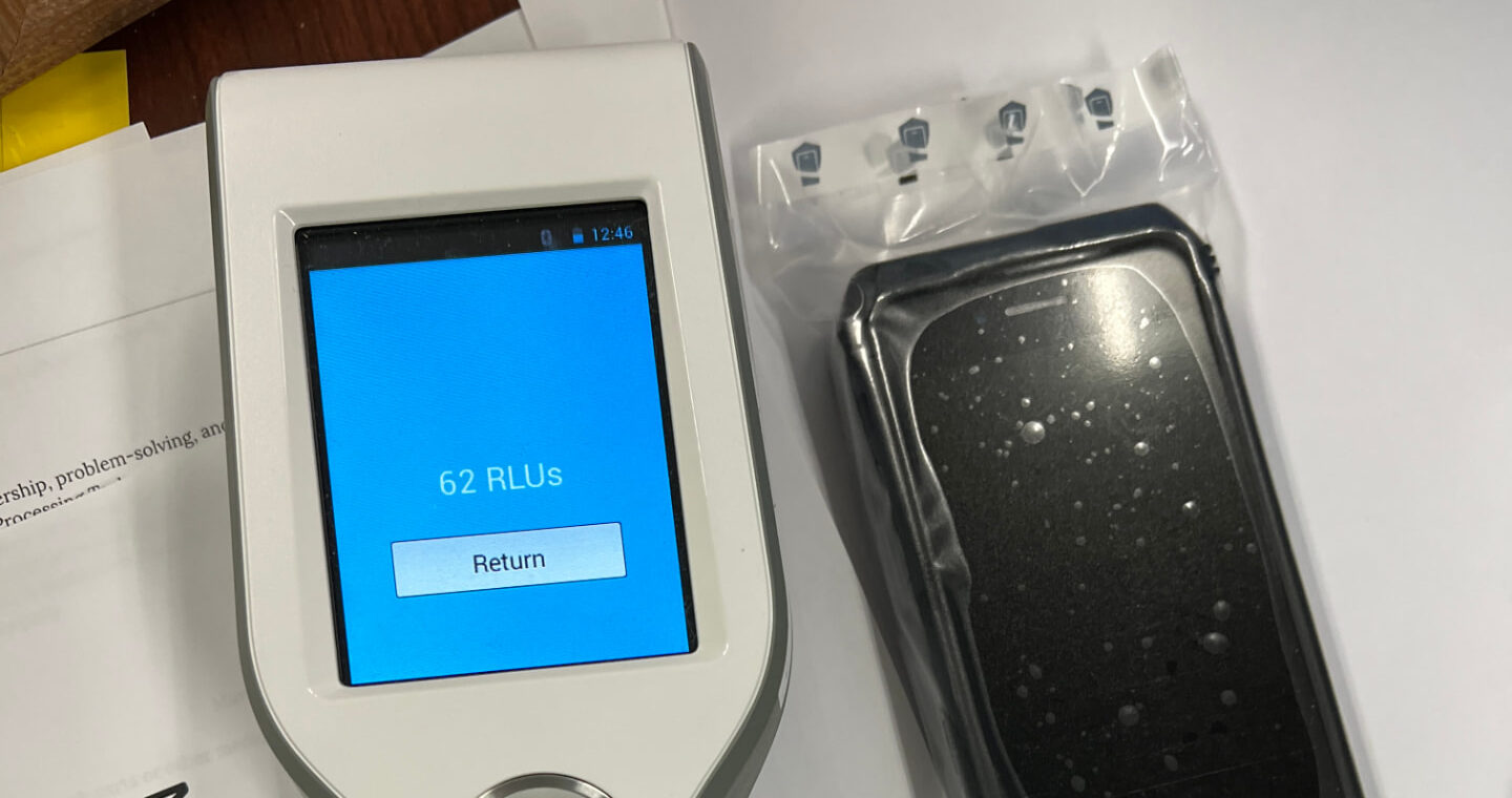 ATP meter reading 62 RLUs beside a WynnShield™-wrapped phone